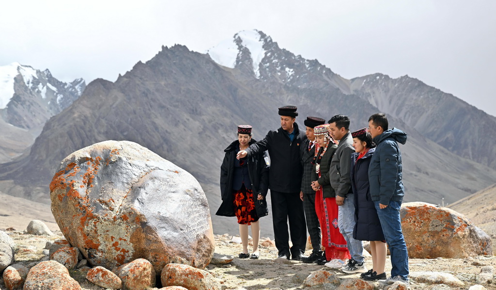 2023年9月21日，在瓦罕走廊，一家四代護(hù)邊的龍吉克·卡德爾（左二）在向家人講述家訓(xùn)石的故事。新華社記者 李響 攝